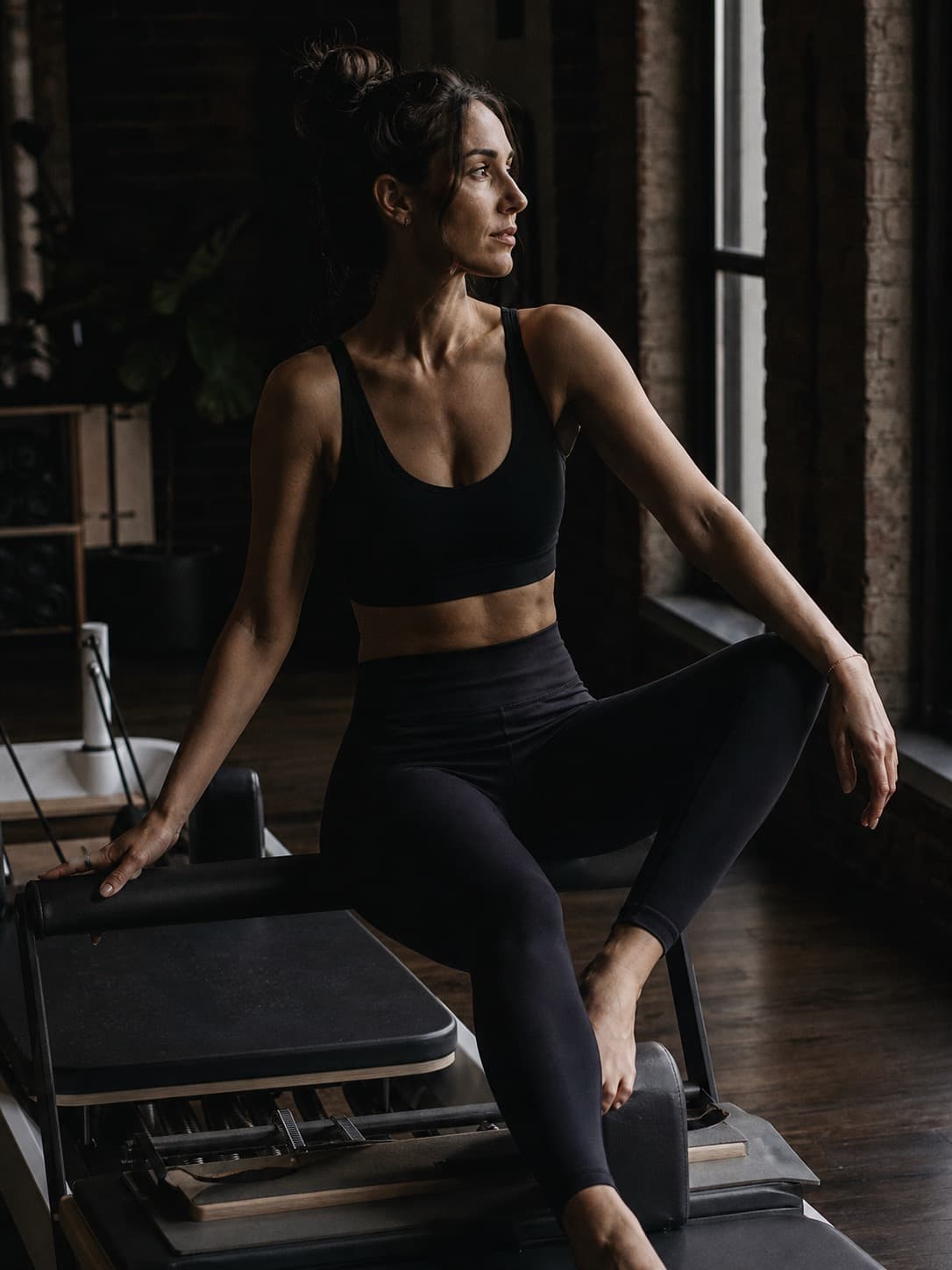 Woman on reformer machine in Brooklyn pilates studio